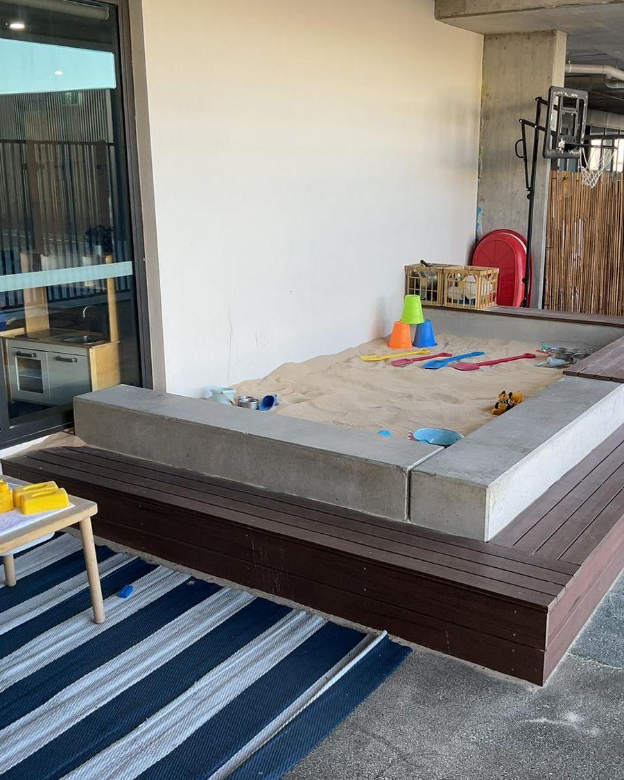 The covered sandpit and a block-play table in the Blooming Buds outdoor area