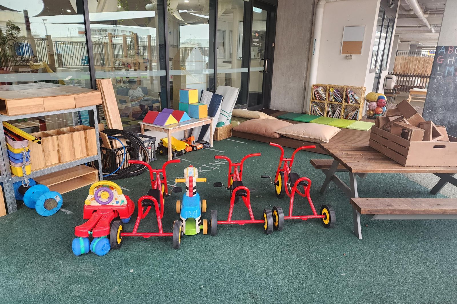 Tricycles, a bike track and play shelves in the Blooming Buds outdoor area